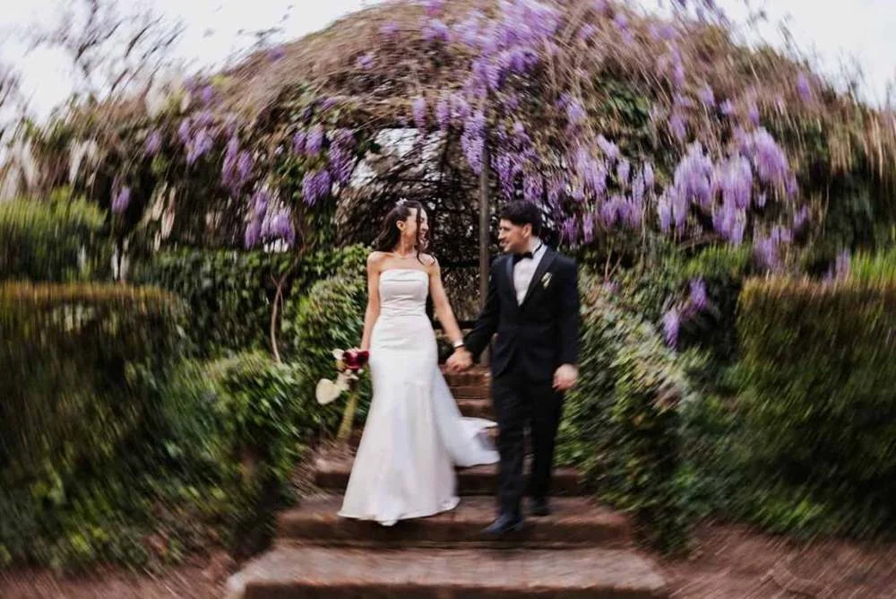Pareja bajo una pérgola con flores, fotografía de Kuma Studio